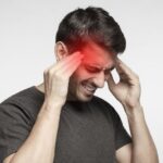 Man experiencing persistent headaches after a head injury, highlighting the importance of neurological evaluation following an accident.