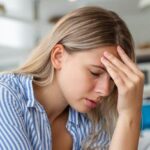 Man experiencing dizziness and headache after a minor head injury, highlighting the risk of serious brain complications despite seemingly mild trauma.