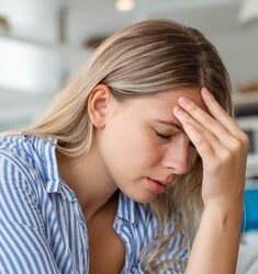 Man experiencing dizziness and headache after a minor head injury, highlighting the risk of serious brain complications despite seemingly mild trauma.